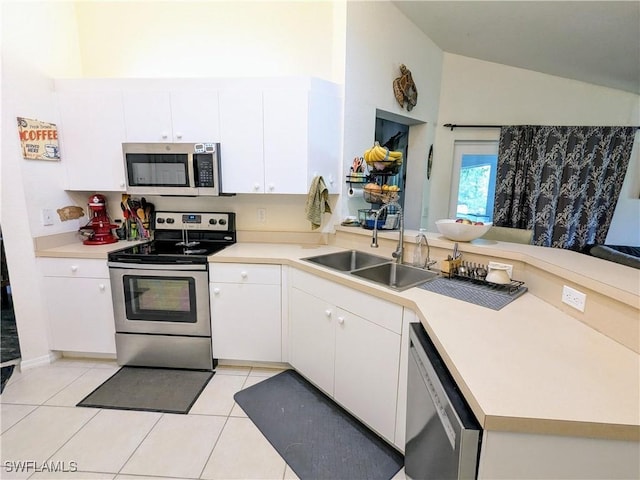 kitchen featuring white cabinets, appliances with stainless steel finishes, kitchen peninsula, and light tile patterned flooring