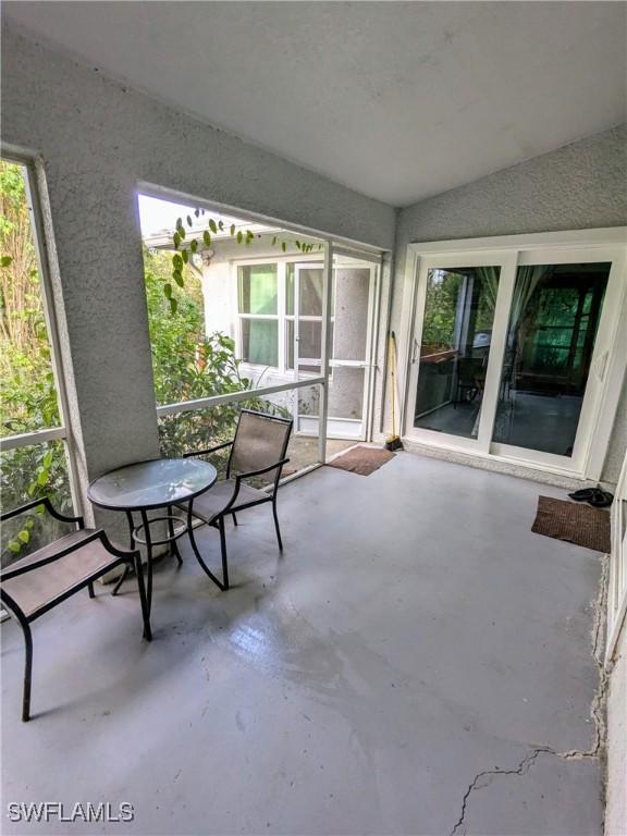 sunroom / solarium featuring vaulted ceiling