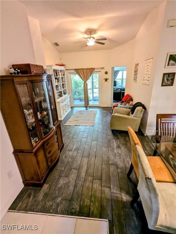 living room with dark hardwood / wood-style flooring and ceiling fan