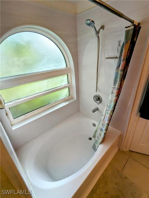 bathroom with tile patterned flooring and shower / bath combo with shower curtain