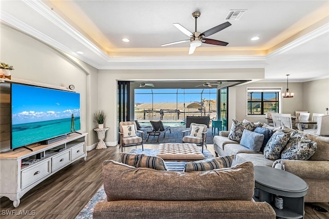 living room featuring a raised ceiling, crown molding, dark hardwood / wood-style flooring, and ceiling fan with notable chandelier