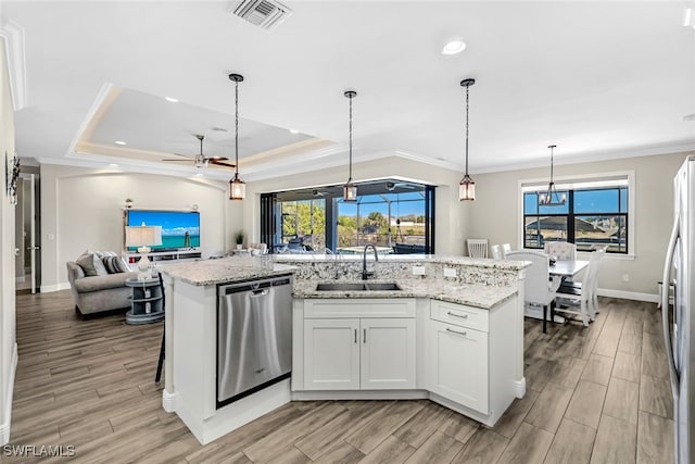 kitchen featuring ceiling fan with notable chandelier, white cabinetry, stainless steel appliances, and an island with sink