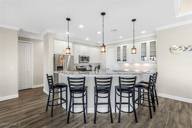 kitchen featuring appliances with stainless steel finishes, decorative light fixtures, white cabinetry, and dark wood-type flooring