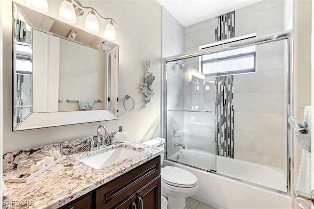 full bathroom featuring shower / bath combination with glass door, tile patterned floors, vanity, and toilet