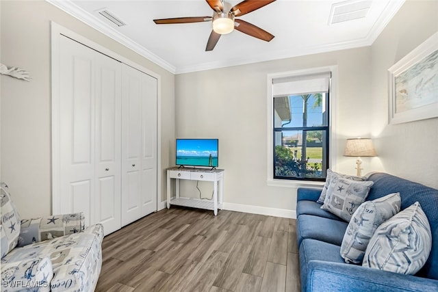 living room with crown molding, ceiling fan, and wood-type flooring