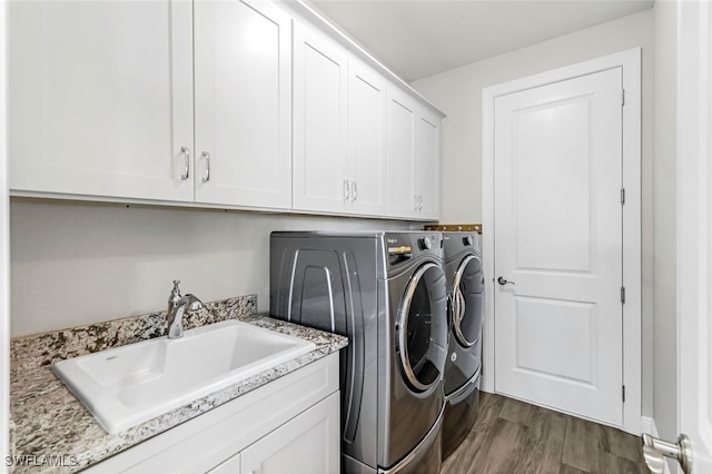 washroom with dark wood-type flooring, cabinets, sink, and washer and dryer