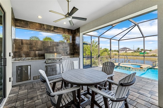 view of patio with glass enclosure, ceiling fan, exterior kitchen, grilling area, and a water view