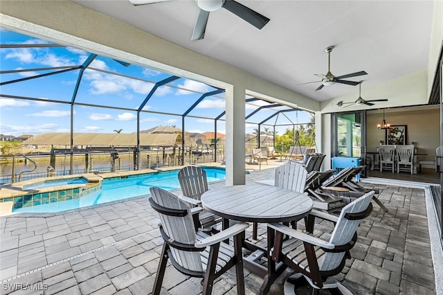 view of patio / terrace with glass enclosure, a swimming pool with hot tub, and a water view