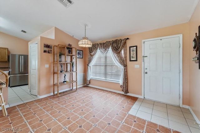 tiled entrance foyer featuring vaulted ceiling