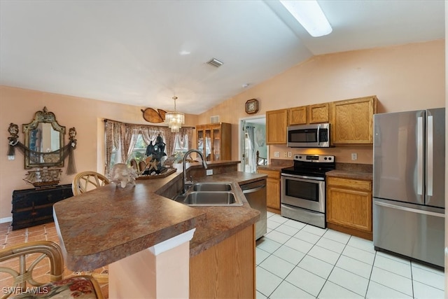 kitchen with a kitchen bar, stainless steel appliances, vaulted ceiling, sink, and hanging light fixtures