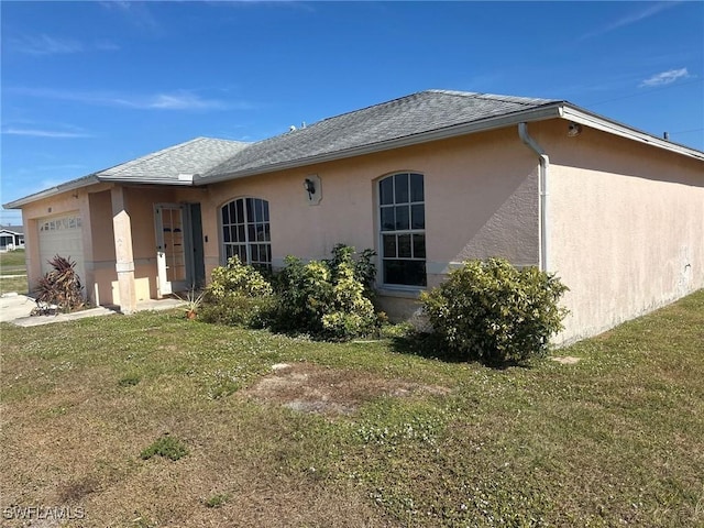 back of house with a lawn and a garage