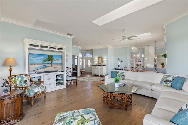 living room with hardwood / wood-style floors, ceiling fan, ornamental molding, and a skylight