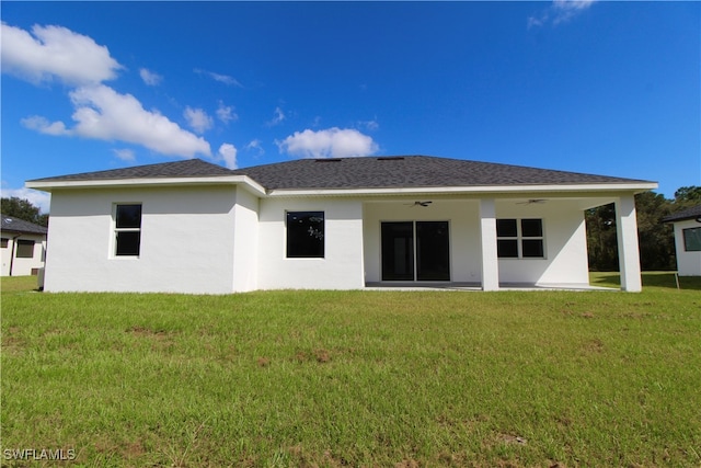 rear view of property featuring a lawn, ceiling fan, and a patio