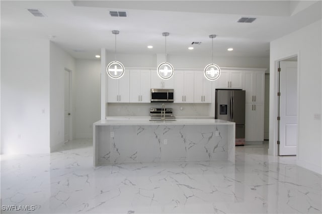 kitchen with pendant lighting, a kitchen island with sink, light stone counters, white cabinetry, and stainless steel appliances