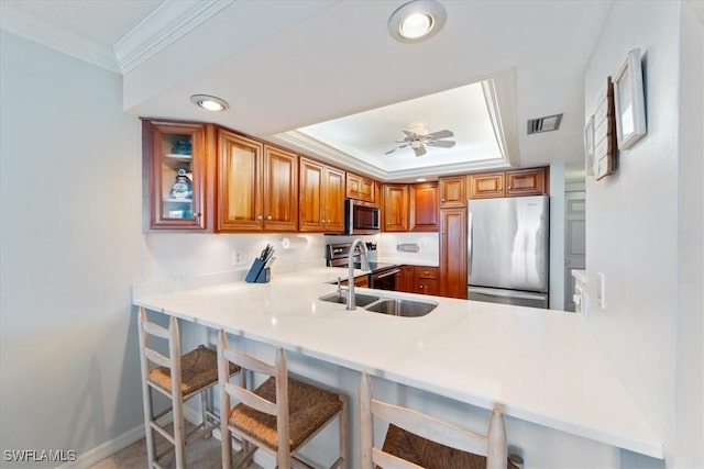 kitchen featuring a kitchen breakfast bar, kitchen peninsula, ceiling fan, and appliances with stainless steel finishes