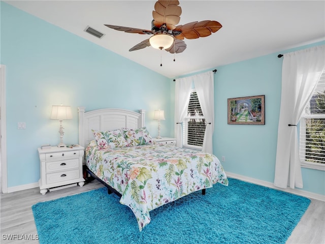 bedroom featuring hardwood / wood-style flooring, vaulted ceiling, and ceiling fan