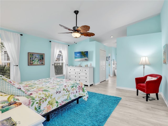 bedroom featuring ceiling fan, a closet, lofted ceiling, and light hardwood / wood-style flooring