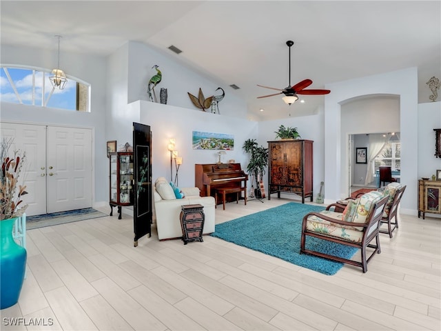 living room with light wood-type flooring, high vaulted ceiling, and ceiling fan