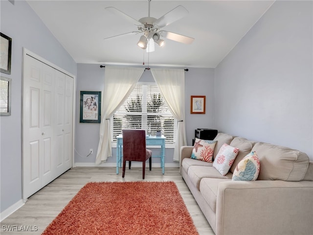 living room featuring ceiling fan, light hardwood / wood-style floors, and vaulted ceiling