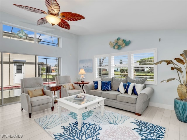 living room featuring plenty of natural light, ceiling fan, light wood-type flooring, and high vaulted ceiling