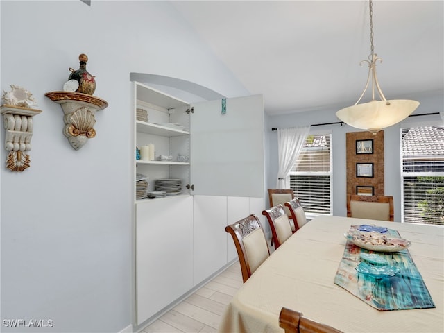 dining room featuring lofted ceiling and light wood-type flooring