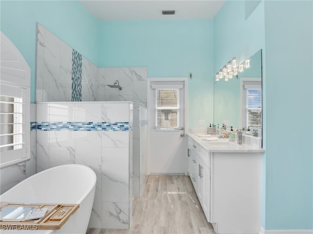 bathroom featuring hardwood / wood-style flooring, vanity, separate shower and tub, and tile walls