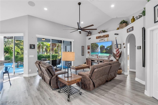 3930 24th Ave SE, Naples, FL 34117 - living room with arched walkways, ceiling fan, light wood-style flooring, baseboards, and plenty of natural light