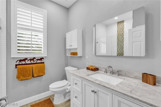 bathroom featuring vanity, toilet, wood-type flooring, and walk in shower