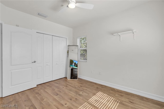 unfurnished bedroom with ceiling fan, a closet, and light wood-type flooring