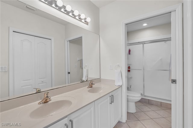 bathroom featuring tile patterned floors, vanity, toilet, and walk in shower