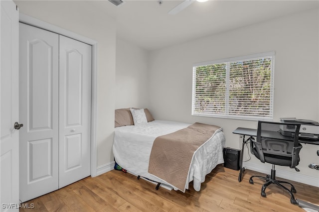 bedroom with hardwood / wood-style floors, ceiling fan, and a closet