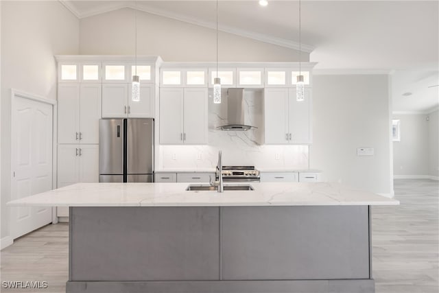 kitchen with appliances with stainless steel finishes, white cabinetry, extractor fan, and a kitchen island with sink