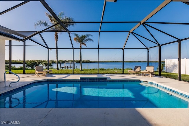 view of pool with glass enclosure, a patio area, and a water view