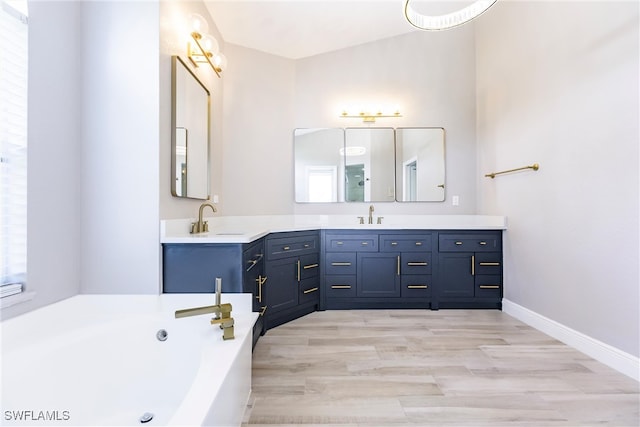 bathroom with a tub, hardwood / wood-style floors, and vanity