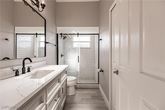 bathroom featuring toilet, vanity, wood-type flooring, and walk in shower