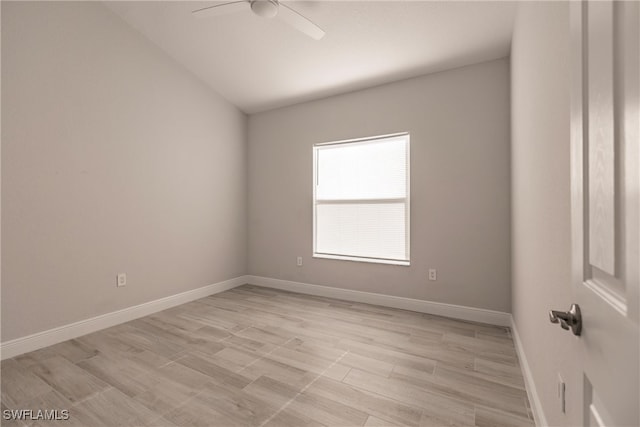 spare room with light hardwood / wood-style floors, vaulted ceiling, and ceiling fan