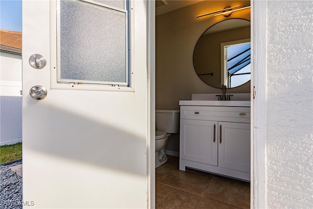 bathroom featuring tile patterned floors, vanity, and toilet