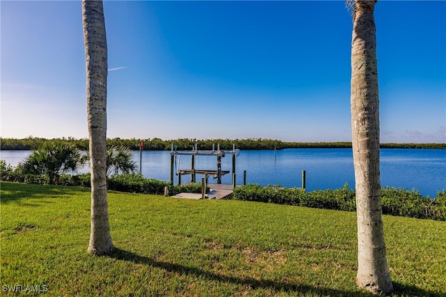 view of dock with a yard and a water view