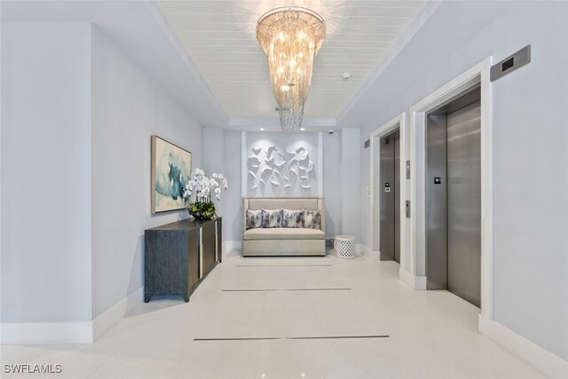 corridor with elevator, tile patterned floors, and an inviting chandelier