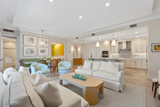 living room with crown molding and light hardwood / wood-style floors