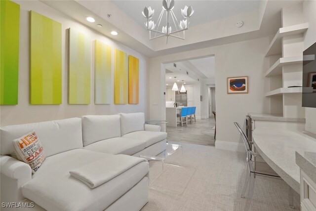 living room with a chandelier and a raised ceiling