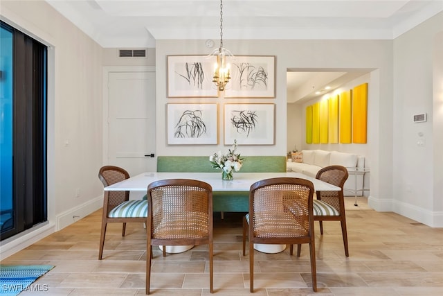 dining area with breakfast area, ornamental molding, light hardwood / wood-style floors, and a chandelier