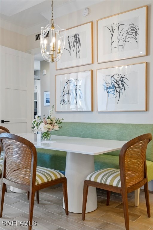 dining area featuring wood-type flooring and a notable chandelier