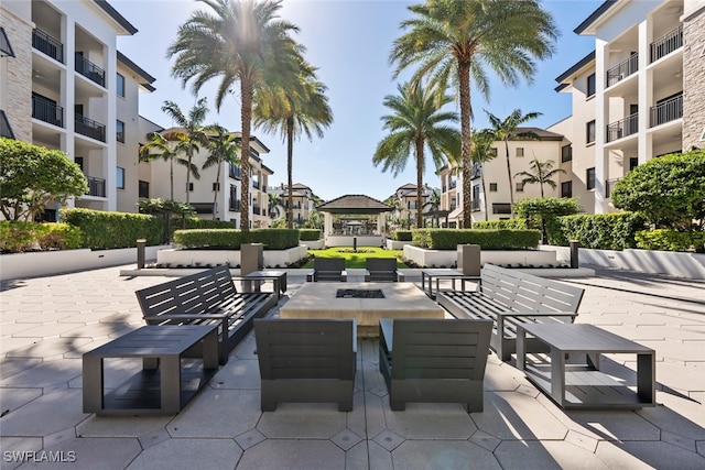 view of property's community with a gazebo, a patio, and an outdoor fire pit