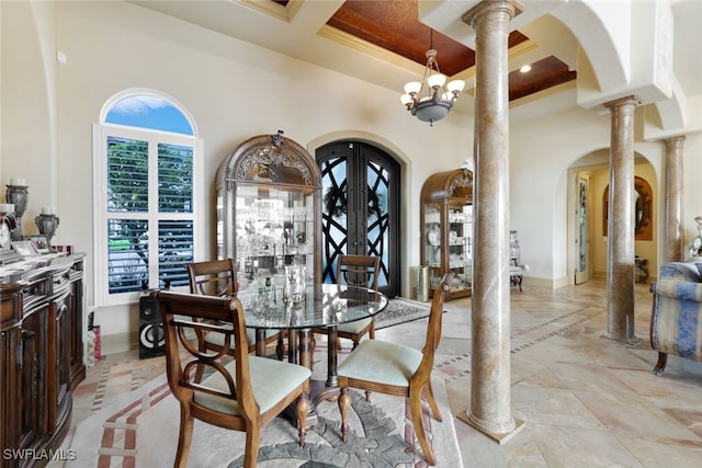 dining room with coffered ceiling, french doors, an inviting chandelier, crown molding, and ornate columns