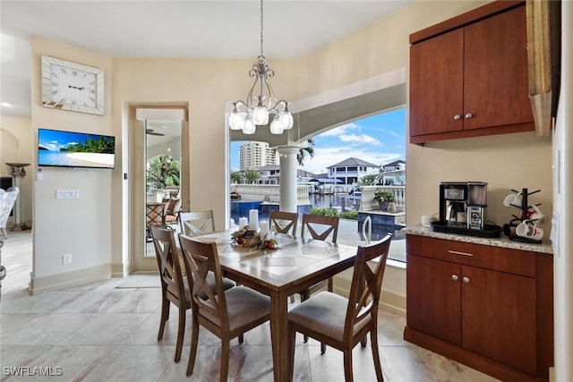 dining room featuring ceiling fan with notable chandelier and decorative columns