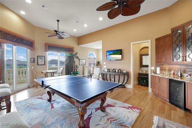 playroom with light wood-type flooring, sink, and wine cooler