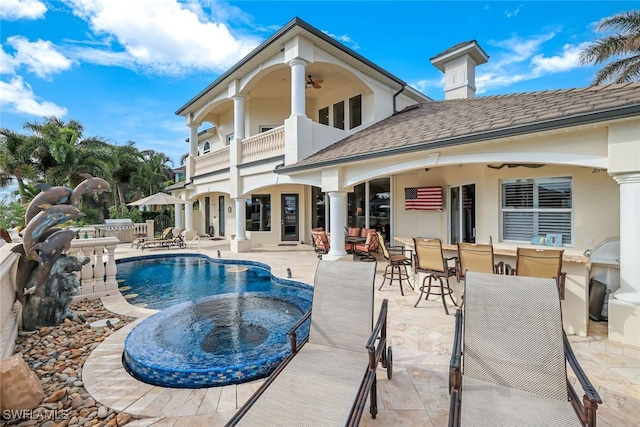 rear view of house with ceiling fan, a patio area, and a balcony