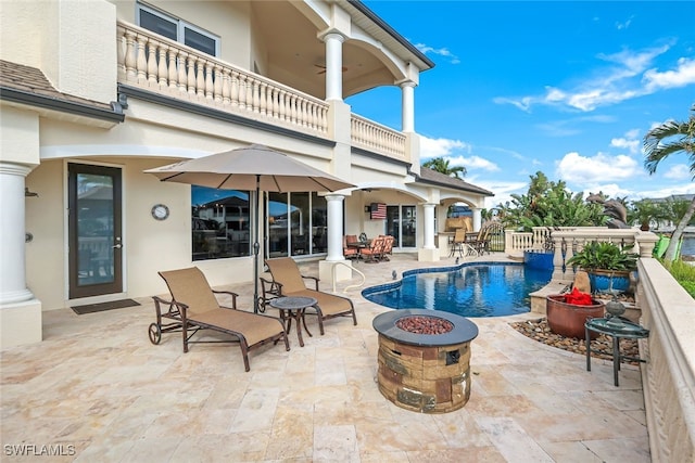 view of swimming pool with a patio and an outdoor fire pit