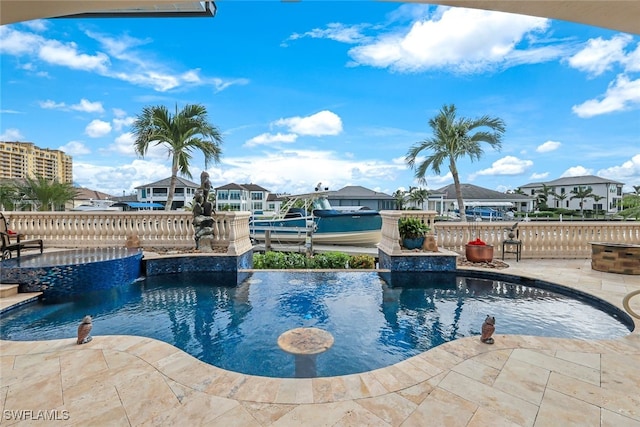 view of pool with pool water feature, a dock, and a patio